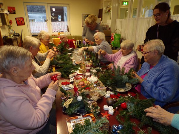 Damen sitzen am Tisch und basteln