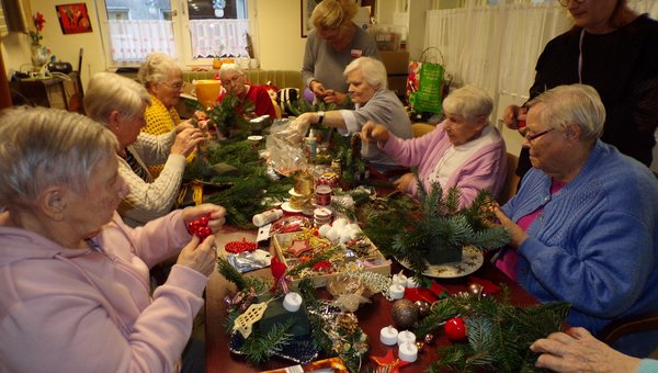 Damen sitzen am Tisch und basteln