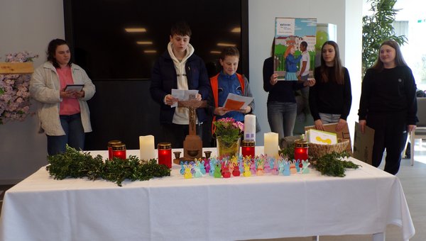 Jugendliche hinter einem geschmückten Tisch