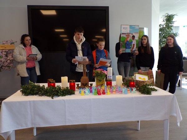 Jugendliche hinter einem geschmückten Tisch